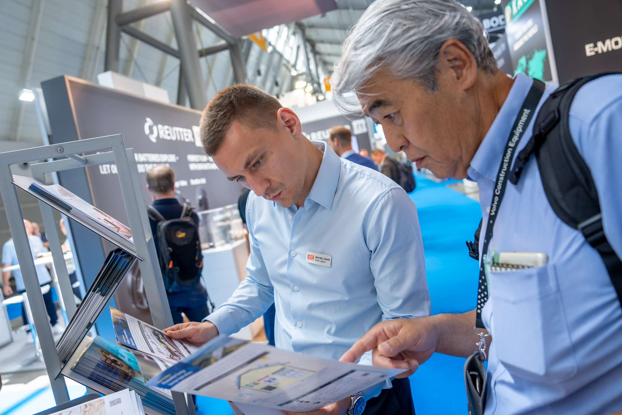 A group of men looking at a bookAI-generated content may be incorrect.